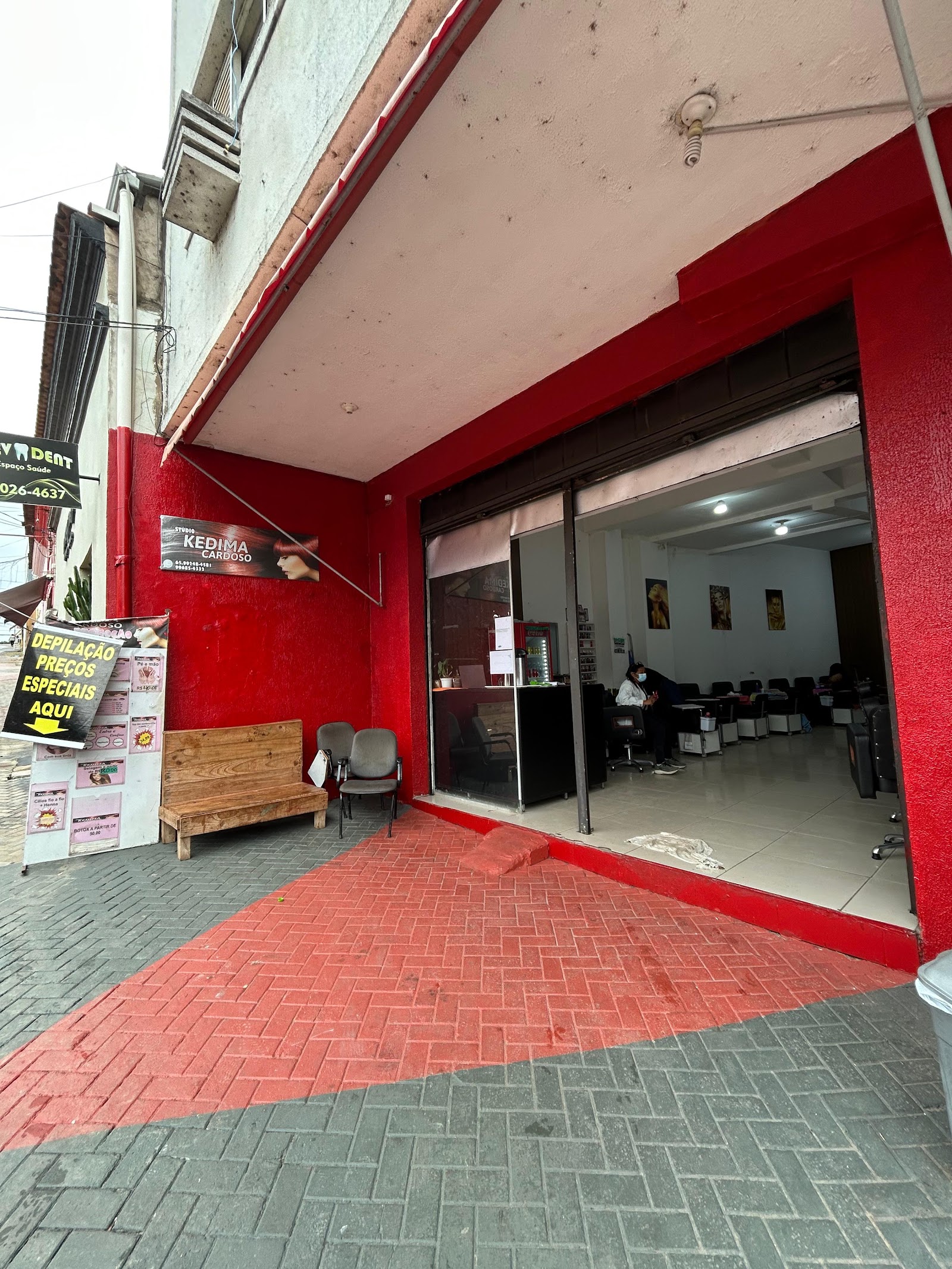 Entrada do Studio Kedma Cardoso vista do Calçadão do Centro-Sul, fachada vermelha com bancos de espera