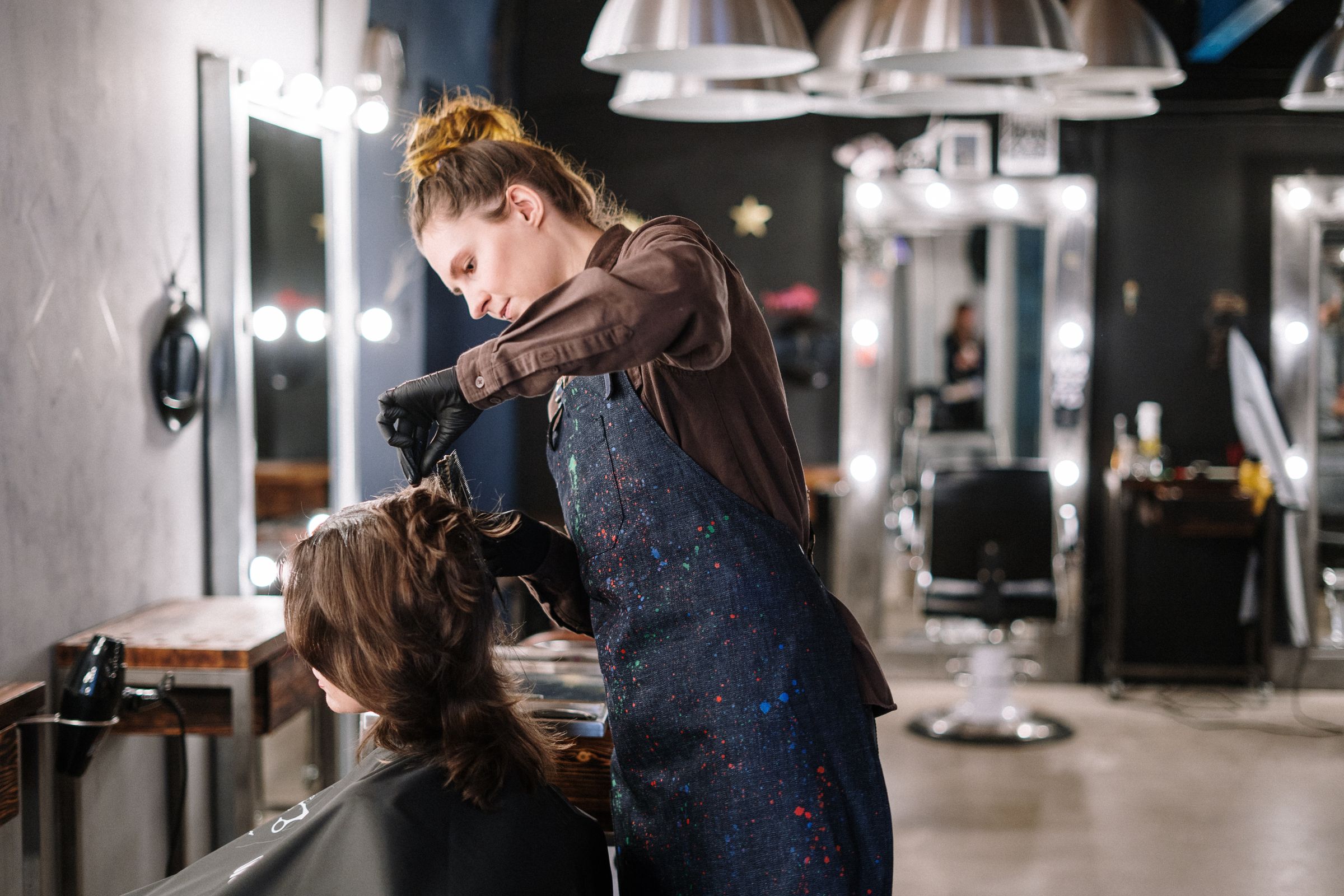 Profissional finalizando o cabelo de uma cliente com atenção aos detalhes
